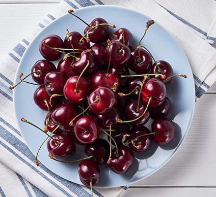 Red ripe  sweet cherry on a plate, on the dining room or kitchen table. Vegetarian, vegan and raw food food and diet. The concept of vegetarianism, veganism and raw food. Vegetable food. From the farm to the table. Ethical consumption.